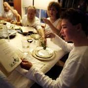 Person reading from the Haggadah while preparing to dip parsley into salt water