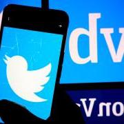 Person holding a phone with Twitter logo in front of a Silicon Valley Bank sign